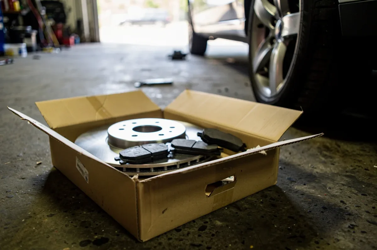 Plaquettes et disque neufs dans leur carton, près de la roue